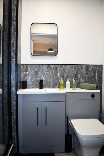 a bathroom with a white sink and a mirror at Bathgate Penthouse near Edinburgh in Bathgate