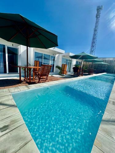 a swimming pool with a table and umbrellas at Pinggan sky in Gretek