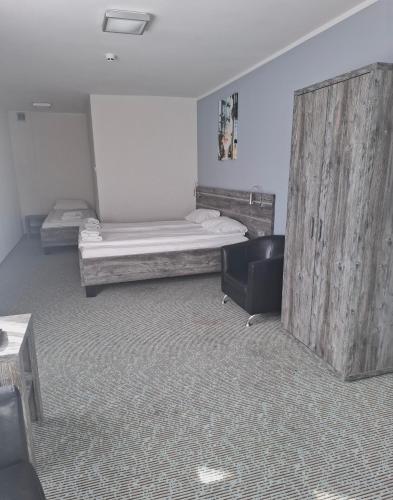 a room with two beds and a chair in it at Hotel Giżycko in Giżycko