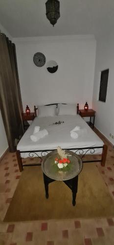 a room with a bed and a table with flowers on it at Riad Dar Fatna in Marrakesh