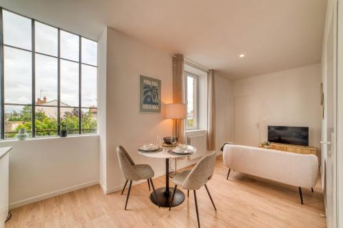 un salon avec une table, des chaises et une télévision dans l'établissement L'Amandier - Superbe appart au coeur de Lyon 5, à Lyon
