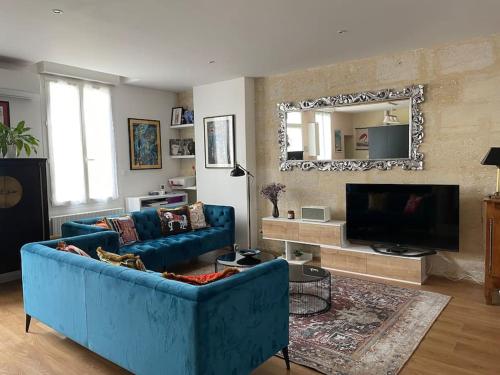 un soggiorno con un divano blu e una TV di Bordeaux centre Maison calme a Bordeaux