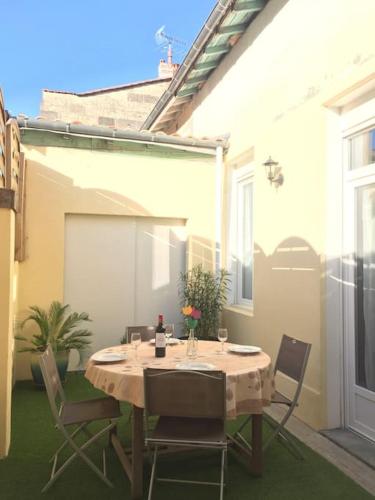 une table et des chaises assises sur une terrasse dans l'établissement Bordeaux centre Maison calme, à Bordeaux