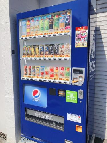 a blue vending machine with drinks and soda at Otaru Garden Stay in Otaru