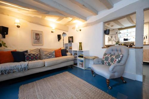 a living room with a couch and a chair at Cosy cottage central Canterbury with free parking in Kent