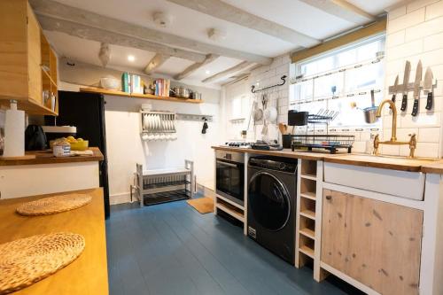 a kitchen with a washer and dryer in it at Cosy cottage central Canterbury with free parking in Kent
