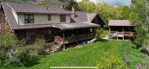 a large house with a porch and a deck at Cozy Canyon Cabin in Vernal