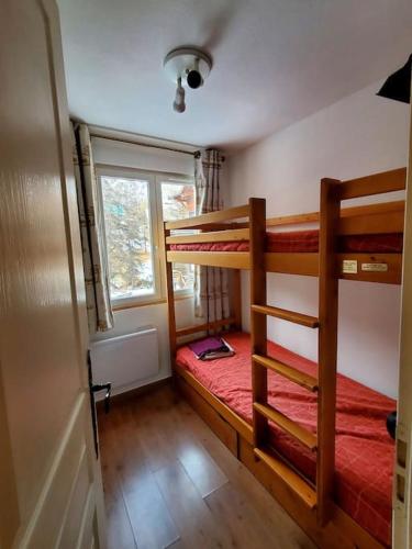 une chambre avec deux lits superposés et une fenêtre dans l'établissement Appartement spacieux, bien situé, à Vars