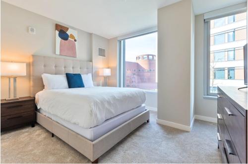 a bedroom with a bed and a large window at Modern Apt in Seaport with Gym in Boston