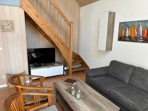 a living room with a couch and a tv at Ferienhaus mit Wasserterrasse - mit Sauna und Kamin - inklusive Nebenkosten in Wendisch Rietz