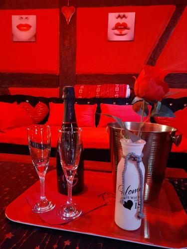 a table with two glasses and a bottle of wine at LOVE ROOM Le rouge et noir in Barr
