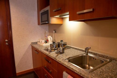 a kitchen with a sink and a counter top at Holiday Inn - Suites Kuwait Salmiya by IHG in Kuwait