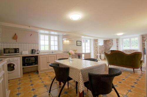 une cuisine avec une table, des chaises et une table. dans l'établissement Gure gostuan, à Itxassou
