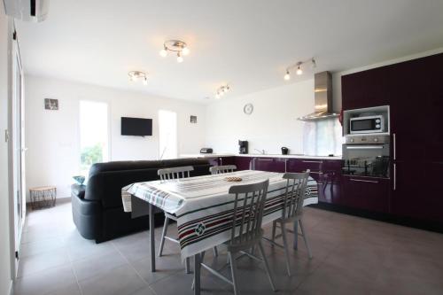 une cuisine et un salon avec une table et un canapé dans l'établissement Larralde-beherria, à Itxassou