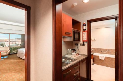 a kitchen with a sink and a room with a bathroom at Holiday Inn Kuwait by IHG in Kuwait