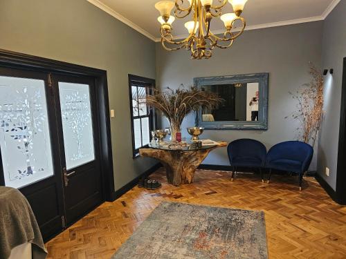 a living room with a table and a mirror at Die Heerenhuys Guest Suites in Stellenbosch