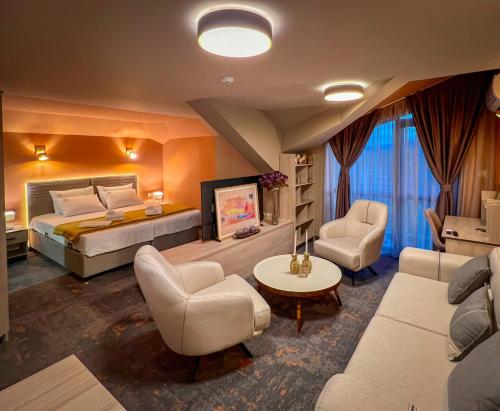 a bedroom with a bed and a couch and chairs at Pino - Villa, Casa, Cucina е Terrazza in Albena