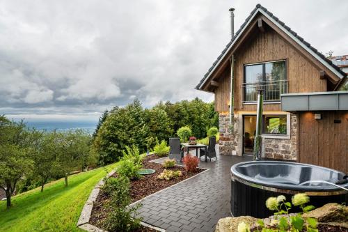 a backyard with a hot tub and a house at Waldlux Luxus-Chalet Brennhus in Kappelrodeck