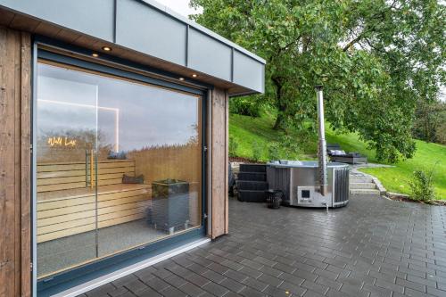 a large glass window of a building with a grill at Waldlux Luxus-Chalet Brennhus in Kappelrodeck