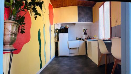 eine Küche mit einem weißen Kühlschrank und einer bunten Wand in der Unterkunft Villa Paulette in Castelnau-le-Lez