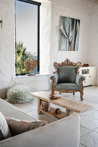 a living room with a chair and a coffee table at Yellow Dream Villas in Chorafakia