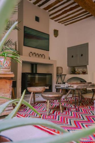 un salon avec une table et des chaises et une cheminée dans l'établissement Grande maison de charme au coeur de Goult, à Goult