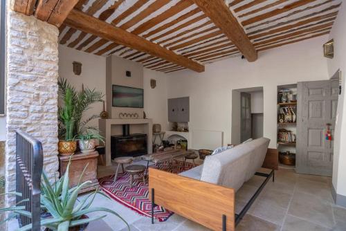 un salon avec un canapé et une cheminée dans l'établissement Grande maison de charme au coeur de Goult, à Goult