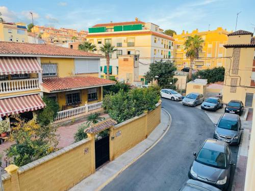 a city street with cars parked on the road at Apartamento Tomillo in Rincón de la Victoria