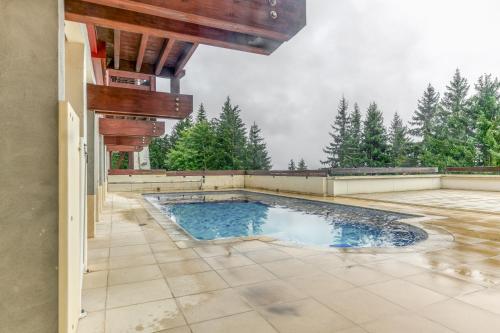 - une piscine sur une terrasse avec des arbres en arrière-plan dans l'établissement Clos des Gentianes, à Le Collet d'Allevard