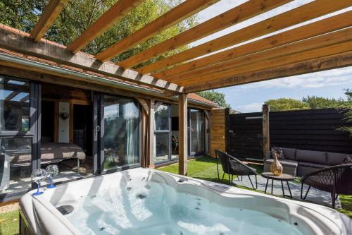 a jacuzzi tub in the backyard of a house at Romantic Countryside Lodge with Hot Tub in North Mundham