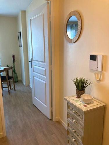a room with a door and a dresser with a mirror at Chez karine 4 in Arpajon