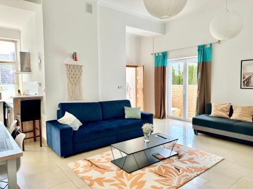 a living room with a blue couch and a table at Komfortowy apartament z tarasem w pobliżu jeziora i Gór Sowich in Bielawa