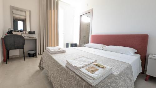 a bedroom with a large bed with a red headboard at L'Ottavo Giorno in Otranto