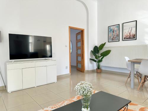 a living room with a tv on a white cabinet at Komfortowy apartament z tarasem w pobliżu jeziora i Gór Sowich in Bielawa