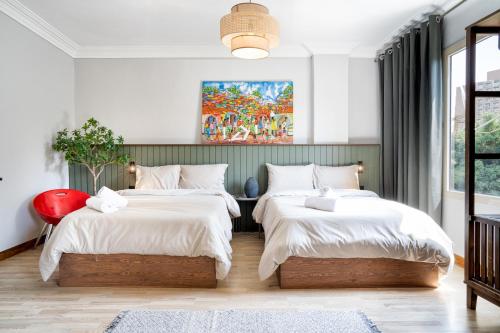 um quarto com duas camas e uma pintura na parede em The Crimson Sun Charm em Cairo