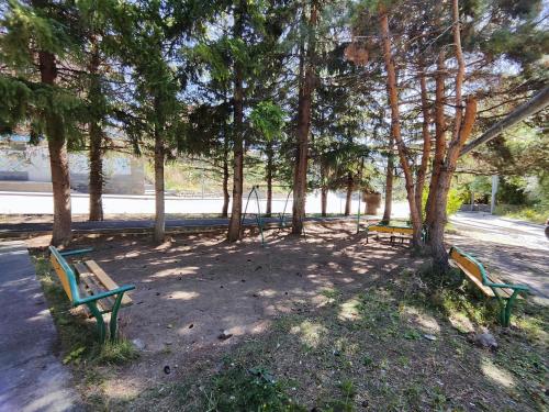 three park benches in a park with trees at Jermuk Mini Apartment in Jermuk