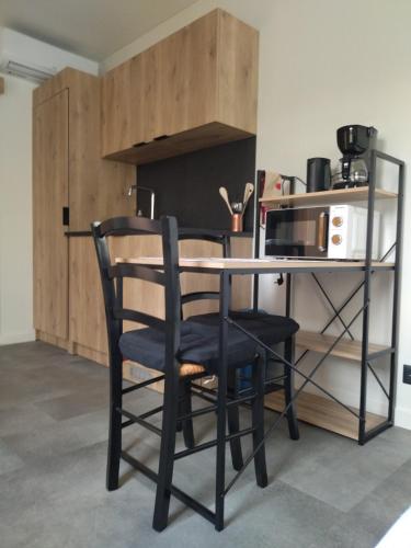 un bureau avec une chaise et une table avec un four micro-ondes dans l'établissement Au coin des Lilas - studio 2, au Mans