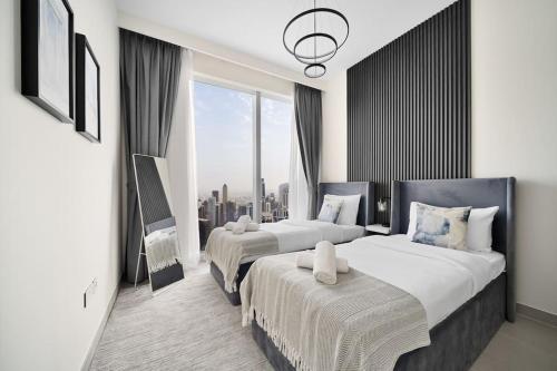 ein Hotelzimmer mit zwei Betten und einem großen Fenster in der Unterkunft Casa Nomad - Full Burj Khalifa & Fountain View at Luxury 4 Bed in Dubai