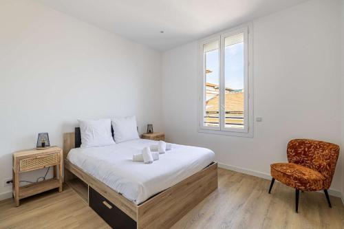 une chambre avec un lit, une chaise et une fenêtre dans l'établissement LE LOGIS CANNOIS au calme en centre-ville, à Cannes