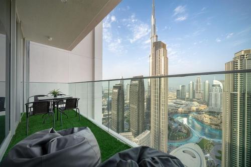 a room with a balcony with a view of a city at Casa Nomad - Full Burj Khalifa & Fountain View at Luxury 4 Bed in Dubai