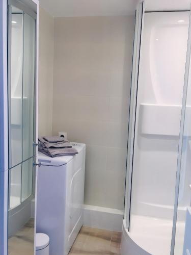 - une buanderie blanche avec lave-linge et sèche-linge dans l'établissement Merveilleux Studio Face La Mer, à Royan