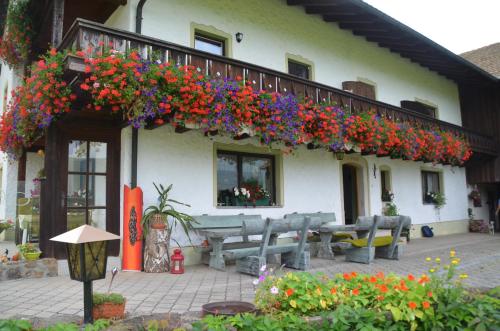 a building with a bunch of flowers on a balcony at Erholung pur am Stroblhof in Arnbruck