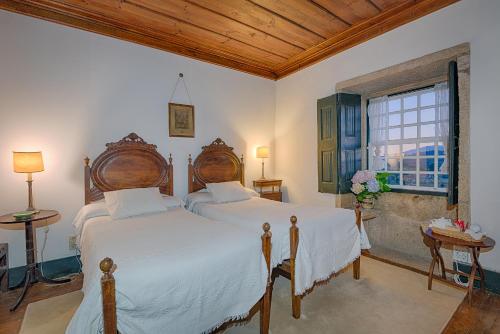 two beds in a bedroom with a window at Paço de Lanheses - Turismo de Habitação in Lanheses