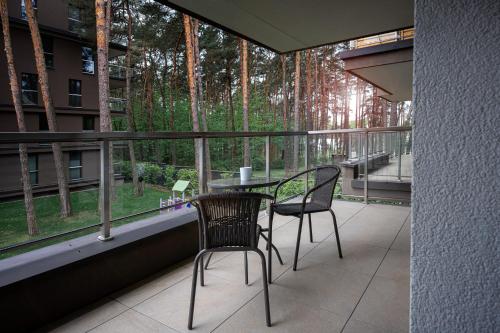 a balcony with a table and two chairs and a window at Sosnowy "3" ,Baseny Tropikalne, Ładowarka do elektryków, Faktura, Parking in Kielce