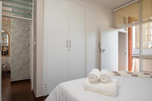 a white bedroom with towels on a bed at 903 Umdloti Resorts in Umdloti