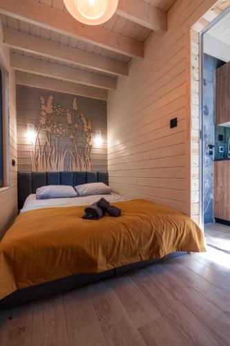a bedroom with a large bed with a wooden wall at Zatoka Bielika Glamping in Sielsko