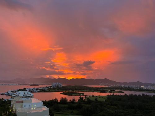 a sunset over a body of water and a city at B1401 - Fourteen at Mullet Bay, Luxurious and Cosy 2bed apartment with the sea view in Cupecoy