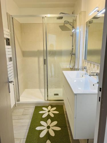 La salle de bains est pourvue d'une douche et d'un tapis vert. dans l'établissement Le Cocon, à Vaux-sur-Mer