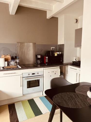 - une cuisine avec des appareils électroménagers blancs et une table dans l'établissement Charmant Duplex Au Coeur Des Minime, à La Rochelle