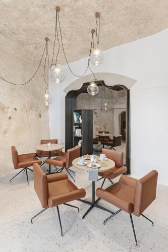 a room with tables and chairs and a fireplace at La Dimora Di Metello in Matera